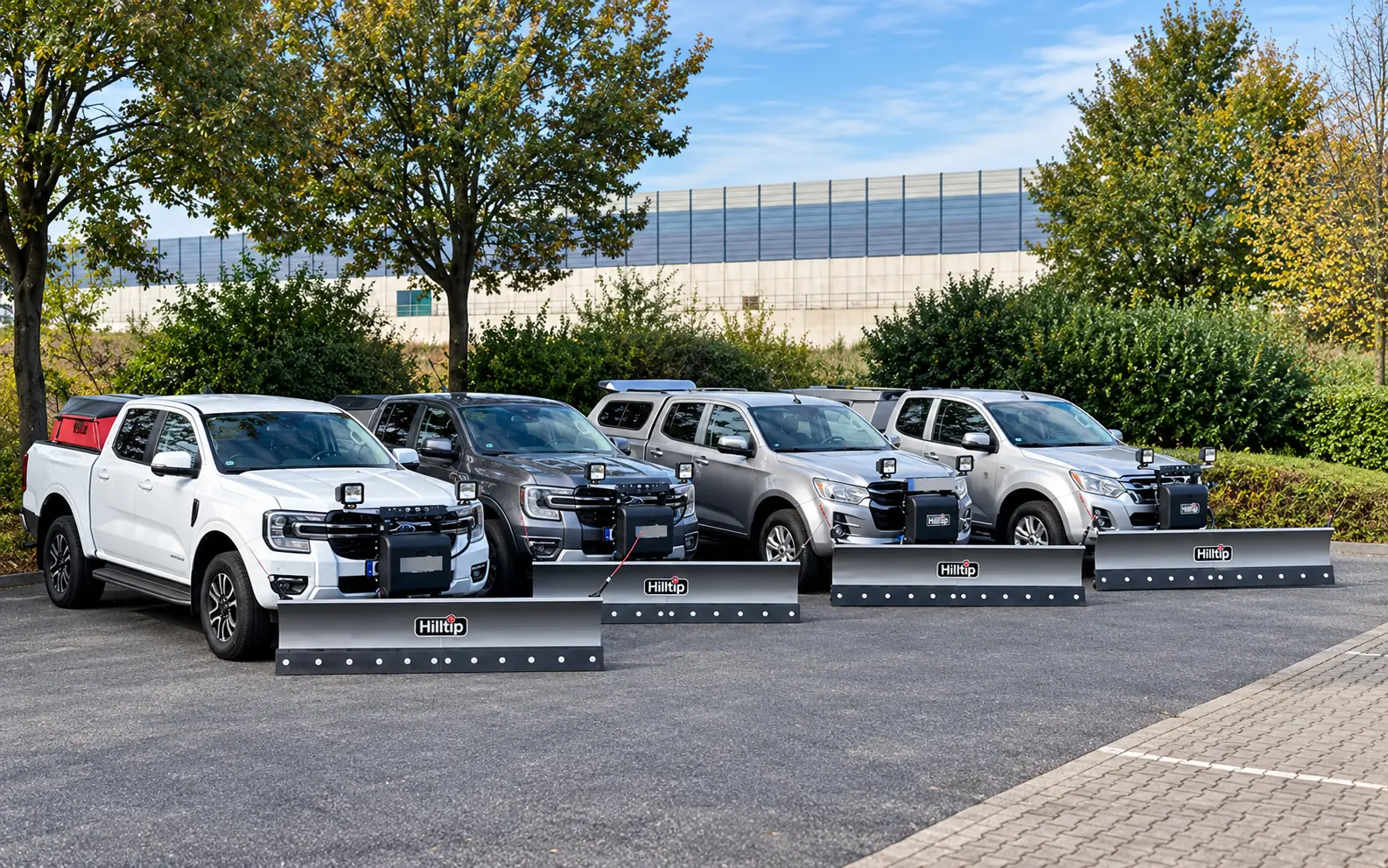 Pickups von Ford und Isuzu mit Hilltip-Schneepflügen auf dem Gelände in Neuss
