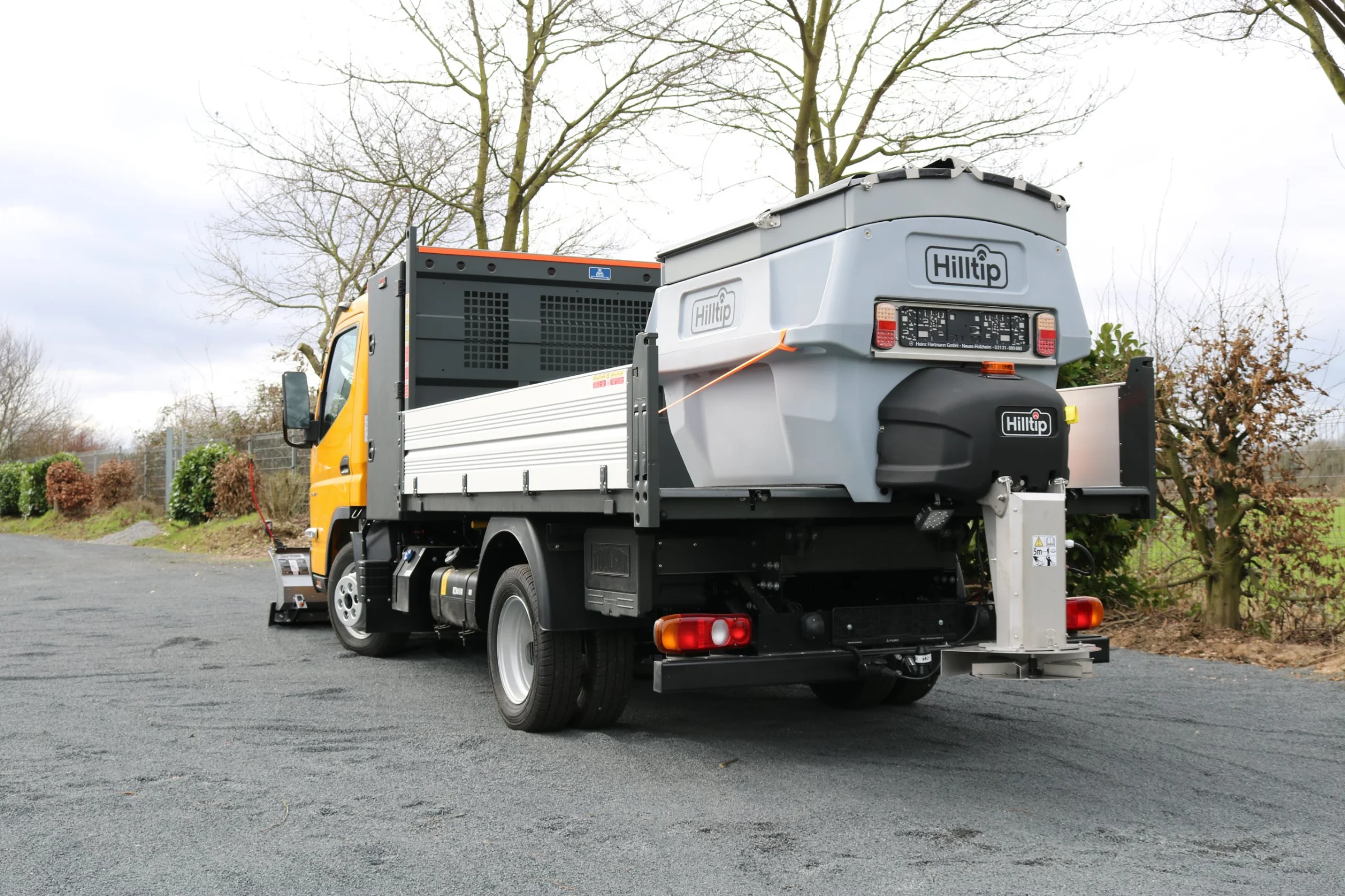 FUSO Canter mit Hilltip SnowStriker Schneepflug, Hilltip IceStriker Streuer, Lichtträger mit LED-Arbeitsscheinwerfern, Dreiseitenkipper mit Aluminium-Bordwänden, Werkzeugkasten hinter der Kabine, Rundumleuchte