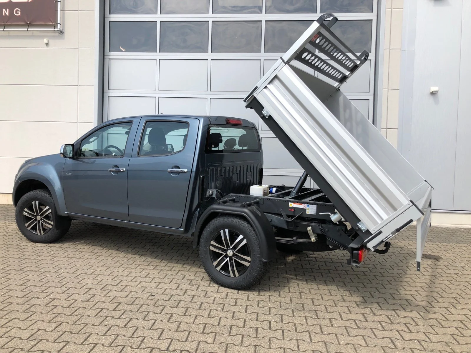 Isuzu D-Max mit Aluminium-Dreiseitenkipper mit Kabinenschutzgitter, Zusatzluftfederung, Bilstein Stoßdämpfer, Hilltip SnowStriker Schneepflug, Hilltip IceStriker Streuer, Quick Hitch Anbausystem, Lichtträger mit LED-Arbeitsscheinwerfern, Hilltip Bedieneinheit mit Joystick