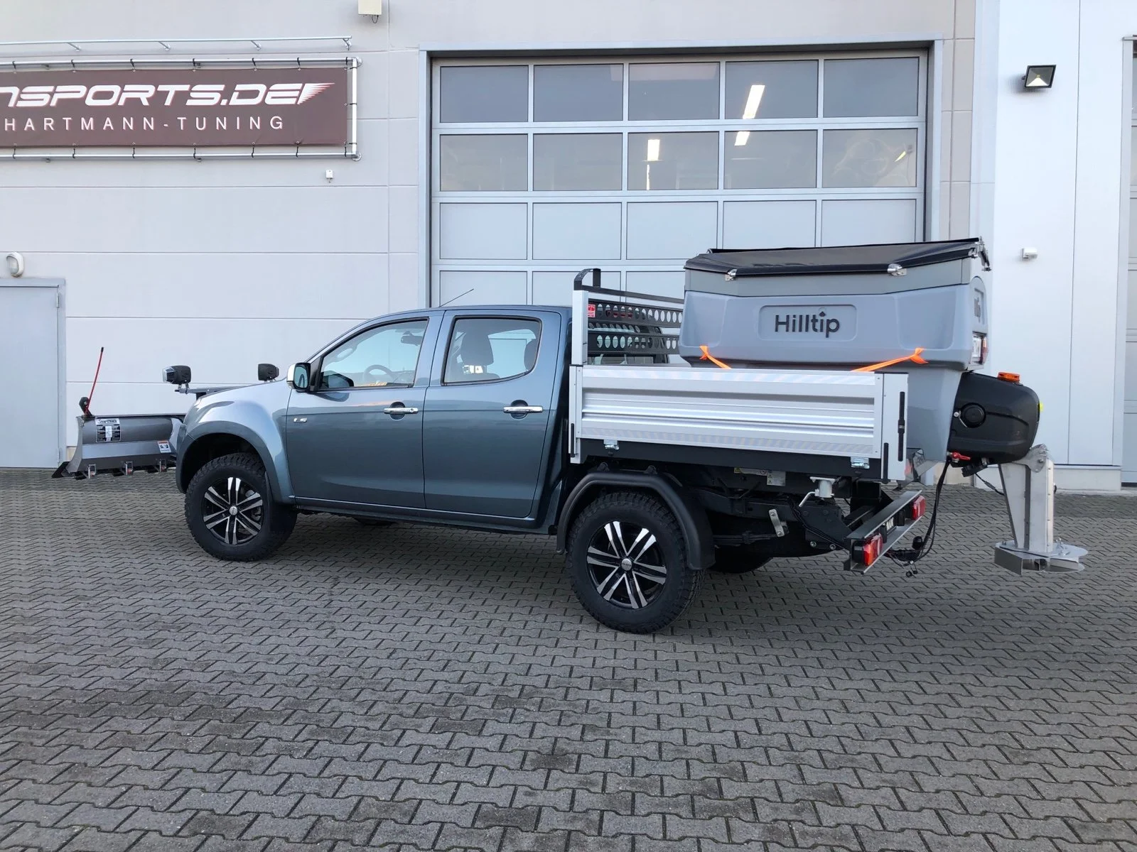 Isuzu D-Max mit Aluminium-Dreiseitenkipper mit Kabinenschutzgitter, Zusatzluftfederung, Bilstein Stoßdämpfer, Hilltip SnowStriker Schneepflug, Hilltip IceStriker Streuer, Quick Hitch Anbausystem, Lichtträger mit LED-Arbeitsscheinwerfern, Hilltip Bedieneinheit mit Joystick