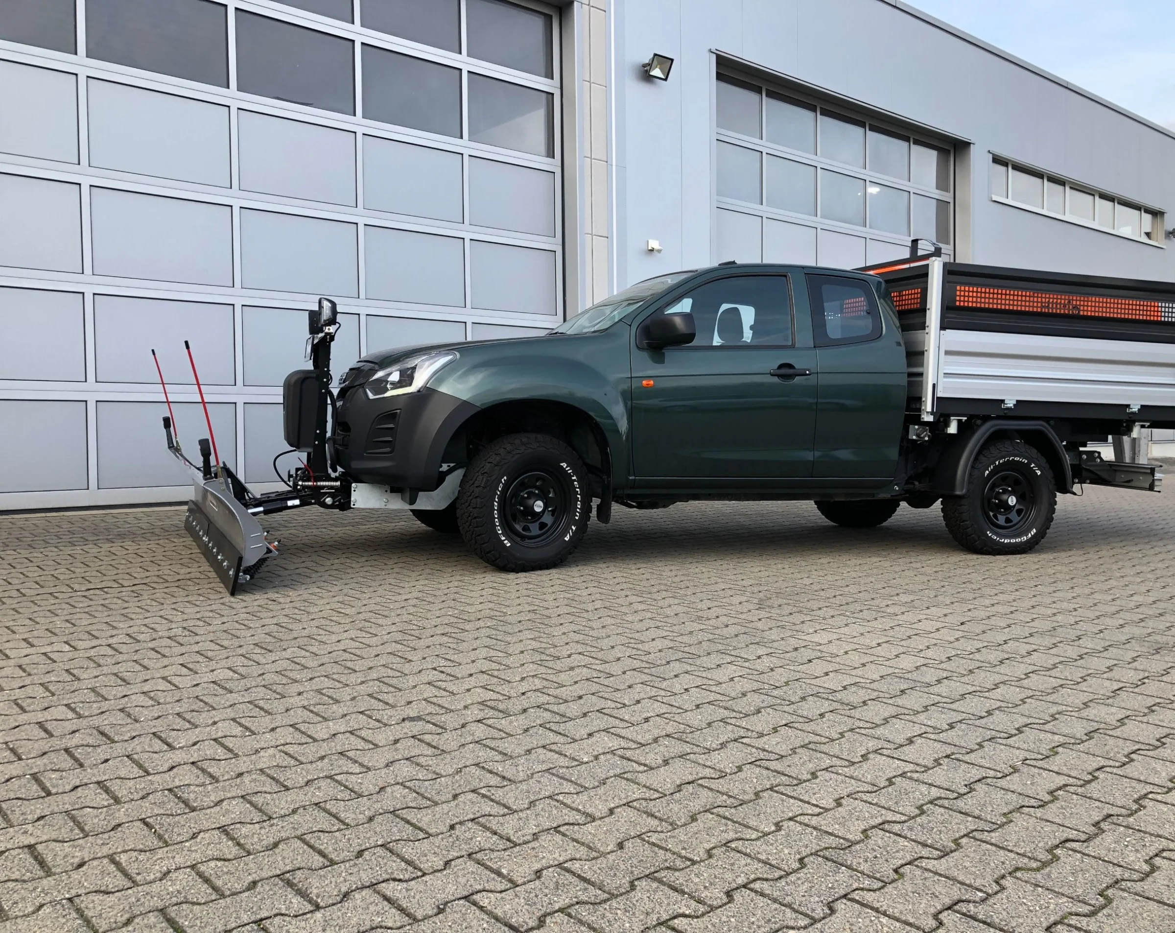 Isuzu D-Max mit Henschel Dreiseitenkipper, Gitteraufsatz für Grünschnitt, Kabinenschutzgitter, Goldschmitt Zusatzluftfederung, Bilstein Stoßdämpfer, DOTZ Stahlfelgen, BFGoodrich All-Terrain T/A KO2 Bereifung, Hilltip SnowStriker Schneepflug, Hilltip IceStriker Streuer, Quick Hitch Anbausystem, Lichtträger mit LED-Arbeitsscheinwerfern