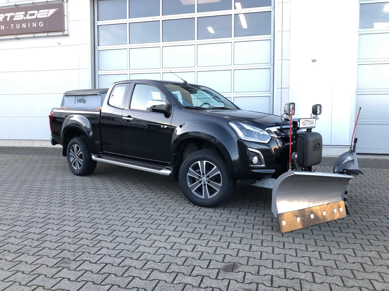 Isuzu D-Max mit Hilltip SnowStriker VP-2250 V-Schneepflug, Hilltip IceStriker 850 Streuer mit GPS, Quick Hitch Anbausystem, Lichtträger mit LED-Arbeitsscheinwerfern, Hilltip Bedieneinheit mit Joystick, Zusatzluftfederung Hinterachse, Verstärkte Federn Vorderachse, Bilstein Stoßdämpfer, Auflastung auf 3.500 kg, Schwerlastfelgen mit AT-Bereifung