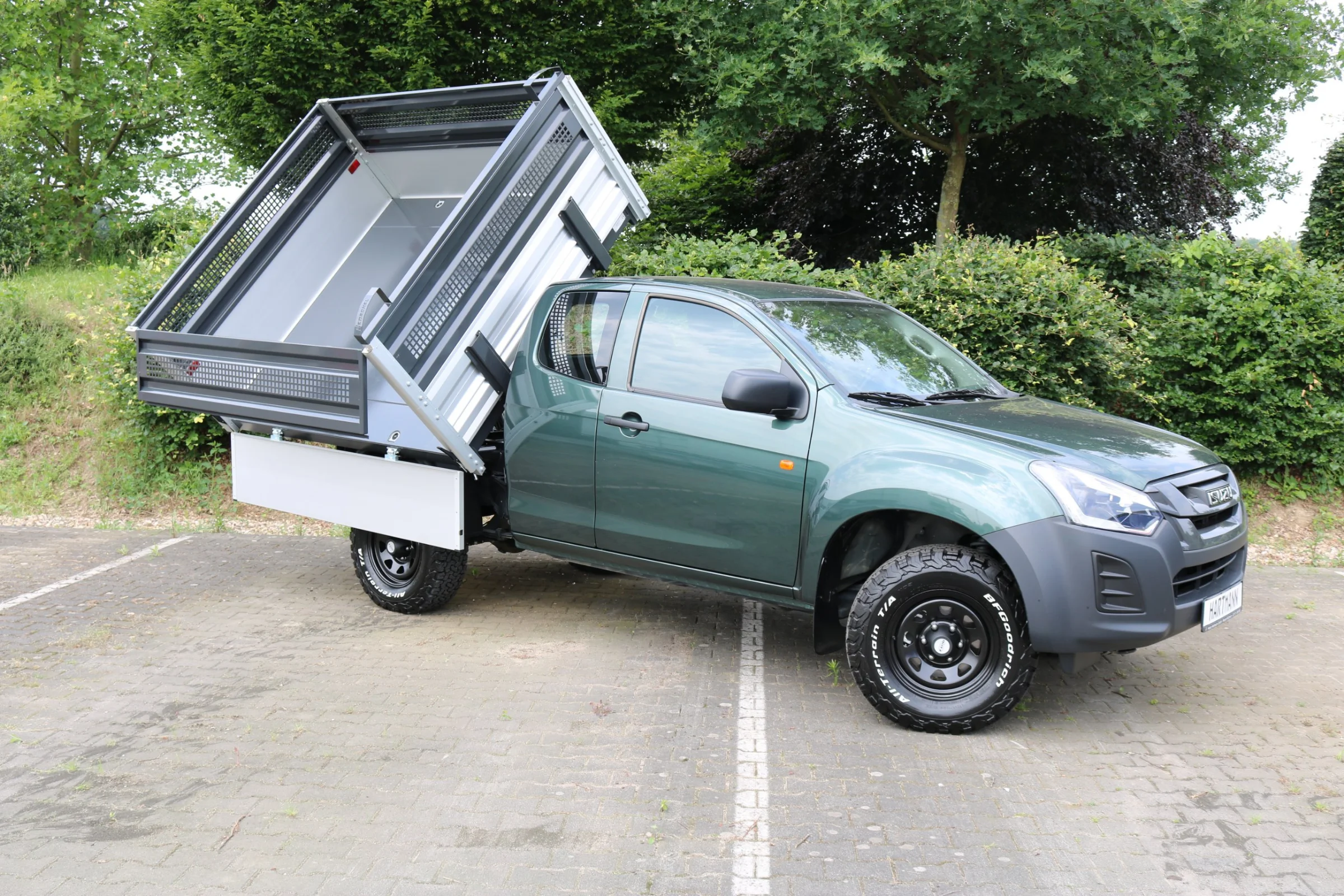 Isuzu D-Max mit Henschel Dreiseitenkipper, Gitteraufsatz für Grünschnitt, Kabinenschutzgitter, Goldschmitt Zusatzluftfederung, Bilstein Stoßdämpfer, DOTZ Stahlfelgen, BFGoodrich All-Terrain T/A KO2 Bereifung, Hilltip SnowStriker Schneepflug, Hilltip IceStriker Streuer, Quick Hitch Anbausystem, Lichtträger mit LED-Arbeitsscheinwerfern