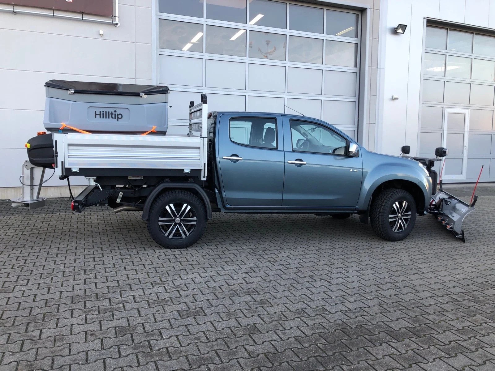 Isuzu D-Max mit Aluminium-Dreiseitenkipper mit Kabinenschutzgitter, Zusatzluftfederung, Bilstein Stoßdämpfer, Hilltip SnowStriker Schneepflug, Hilltip IceStriker Streuer, Quick Hitch Anbausystem, Lichtträger mit LED-Arbeitsscheinwerfern, Hilltip Bedieneinheit mit Joystick