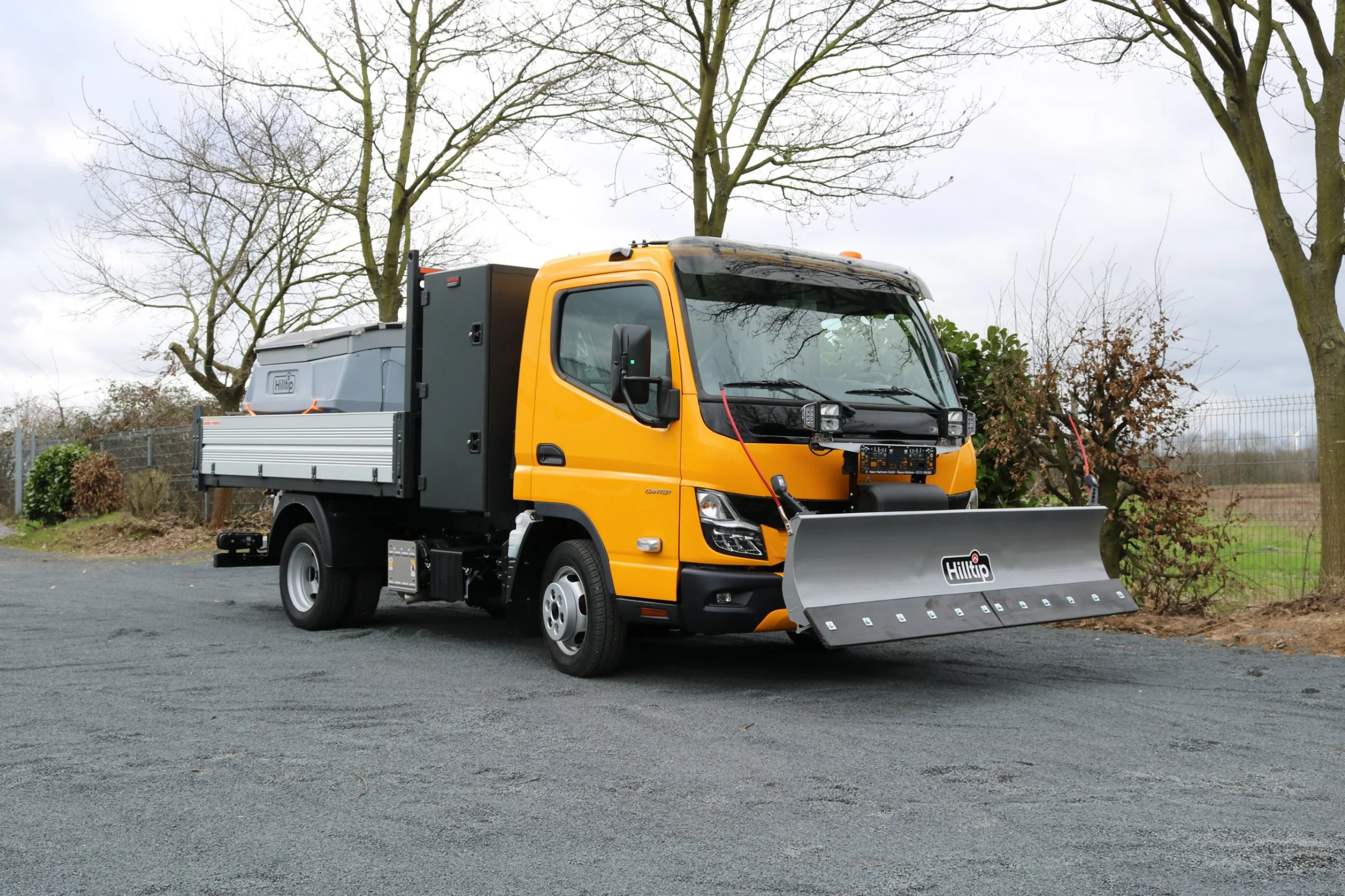 FUSO Canter mit Hilltip SnowStriker Schneepflug, Hilltip IceStriker Streuer, Lichtträger mit LED-Arbeitsscheinwerfern, Dreiseitenkipper mit Aluminium-Bordwänden, Werkzeugkasten hinter der Kabine, Rundumleuchte