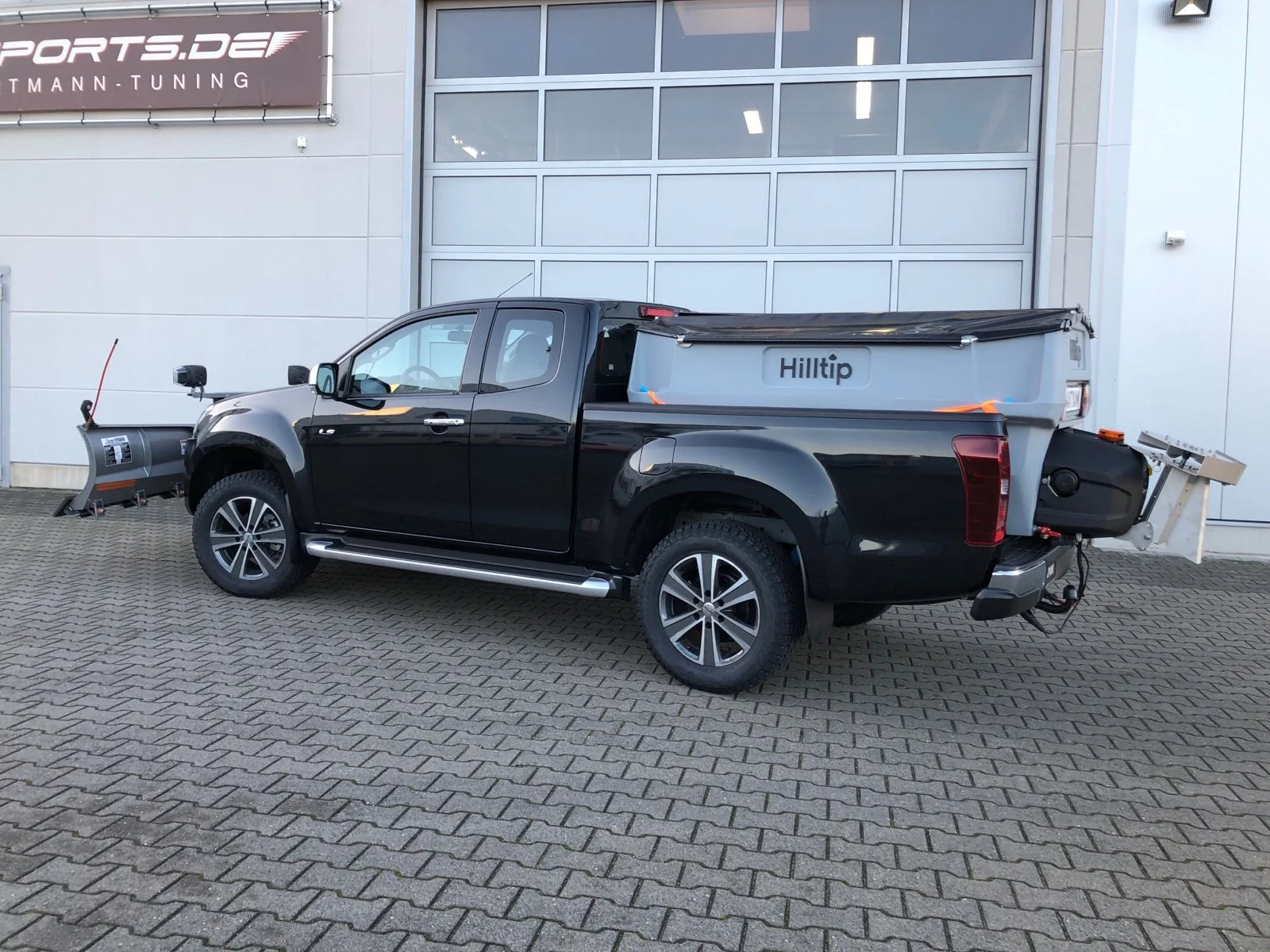 Isuzu D-Max mit Hilltip SnowStriker VP-2250 V-Schneepflug, Hilltip IceStriker 850 Streuer mit GPS, Quick Hitch Anbausystem, Lichtträger mit LED-Arbeitsscheinwerfern, Hilltip Bedieneinheit mit Joystick, Zusatzluftfederung Hinterachse, Verstärkte Federn Vorderachse, Bilstein Stoßdämpfer, Auflastung auf 3.500 kg, Schwerlastfelgen mit AT-Bereifung